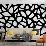 Black and white geometric wallpaper creating dramatic impact in a modern minimalist living room with natural lighting