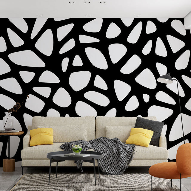 Black and white geometric wallpaper creating dramatic impact in a modern minimalist living room with natural lighting