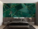 Geometric emerald green and gold wallpaper in modern living room setting with gray sofa and pendant lights