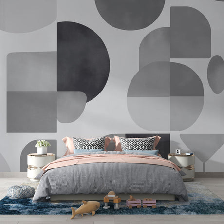 Modern geometric wallpaper with circles and shapes creating depth in a minimalist living room with grey sofa and natural light