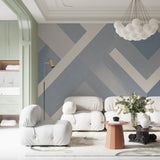 Modern geometric wallpaper in a bright living room with grey sofa and large windows