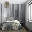 Modern grey stripe wallpaper in a minimalist living room with natural light highlighting the gradient pattern