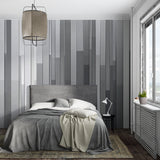 Modern grey stripe wallpaper in a minimalist living room with natural light highlighting the gradient pattern