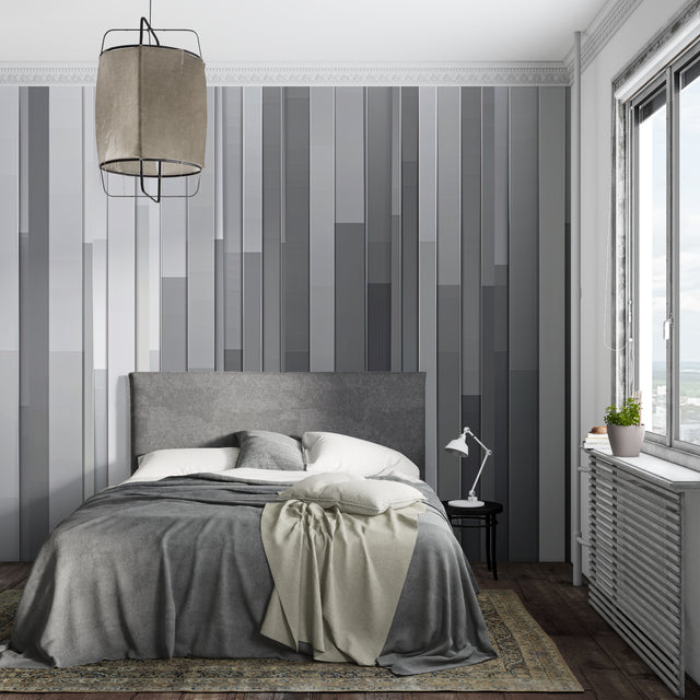 Modern grey stripe wallpaper in a minimalist living room with natural light highlighting the gradient pattern