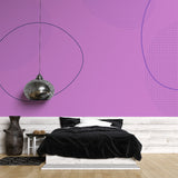 Modern purple geometric wallpaper mural creating depth in a minimalist living room with grey furniture