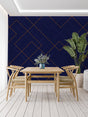 Navy blue and gold geometric wallpaper in modern living room with grey sofa and brass accents