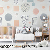 Geometric nursery wallpaper with pastel shapes brightening a modern baby room with white furniture