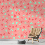 Pink geometric triangle wallpaper with mint accents shown in a bright modern home office with minimalist furniture