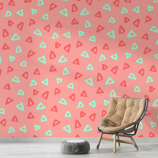 Pink geometric triangle wallpaper with mint accents shown in a bright modern home office with minimalist furniture