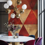 Geometric red and gold triangle wallpaper in modern living room with grey sofa and pendant lighting
