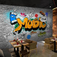 Graffiti wallpaper mural creating bold impact in modern teen bedroom with gaming setup and LED lights