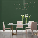Forest green wall covering in a home office with wooden furniture