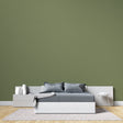Modern green wall mural in bright living room showing peaceful khaki tones
