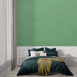Sage green wall mural creating a calm bedroom atmosphere with minimal decor