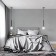 Modern grey wallpaper mural in a minimalist living room with natural light highlighting its subtle texture