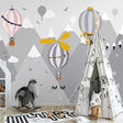 Hot air balloon nursery wallpaper creating a dreamy atmosphere in a soft pink kids bedroom with mountain views