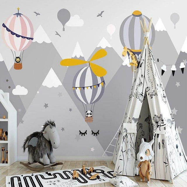 Hot air balloon nursery wallpaper creating a dreamy atmosphere in a soft pink kids bedroom with mountain views