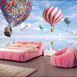 Hot air balloon wallpaper in bright nursery with white furniture showing floating house and colorful balloons