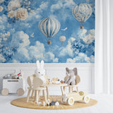 Blue sky balloon wallpaper installed in a cozy reading nook with soft cushions
