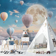 Hot air balloon wallpaper creating a magical atmosphere in a cozy nursery with soft lighting