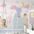 Pink hot air balloon nursery wallpaper creating a magical atmosphere in a modern baby room with white furniture