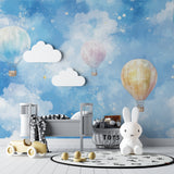 Playroom with hot air balloon wall mural showing soft pastel colors and floating clouds