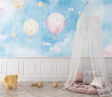 Hot air balloon wallpaper in a cozy nursery with soft lighting showing floating balloons and stars