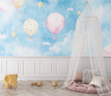 Hot air balloon wallpaper in a cozy nursery with soft lighting showing floating balloons and stars