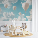 Cloud wallpaper with hot air balloons transforming a playroom into an adventure space