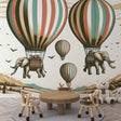 Hot air balloon wallpaper with flying elephants creating a magical atmosphere in a bright nursery with reading nook