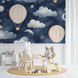 Hot air balloon wallpaper in a cozy nursery with soft lighting showing pink balloons against starry night sky