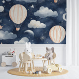 Hot air balloon wallpaper in a cozy nursery with soft lighting showing pink balloons against starry night sky
