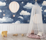 Night sky mural with hot air balloons creating magic in a children's reading nook