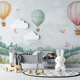 Hot air balloon nursery wallpaper creating a dreamy atmosphere in a modern white nursery with natural wood furniture