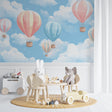 Hot air balloon wallpaper bringing whimsy to a bright nursery with white furniture and soft textiles