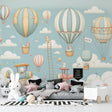 Hot air balloon nursery wallpaper with teddy bears creates a dreamy atmosphere in a modern white and gray nursery with rocking chair
