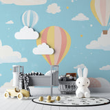 Playroom with balloon wallpaper mural showing peaceful sky scene and gentle pastel tones