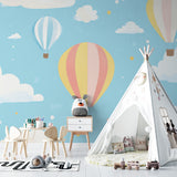 Baby room with hot air balloon wall mural creating a soft, dreamy environment