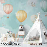 Hot air balloon nursery wallpaper in a bright, modern nursery with white furniture and soft textiles