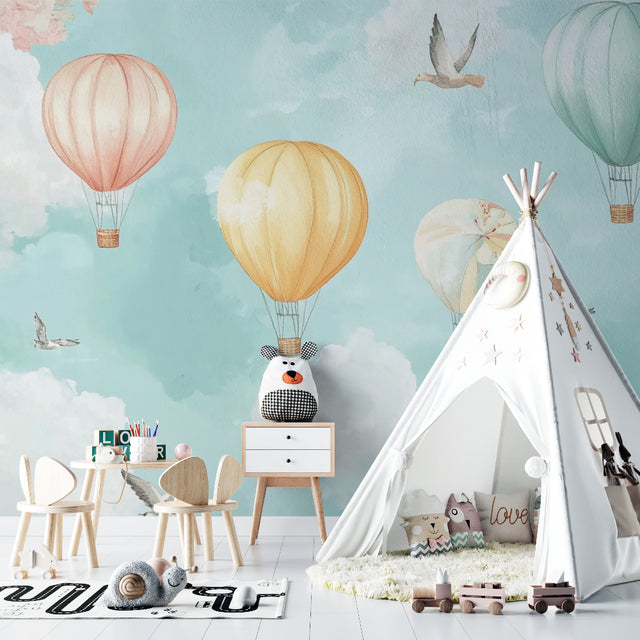 Hot air balloon nursery wallpaper in a bright, modern nursery with white furniture and soft textiles
