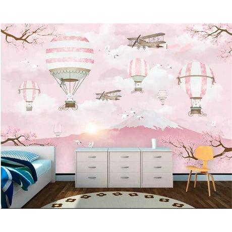 Hot air balloon wallpaper creating a magical atmosphere in a bright nursery with pink accents and white furniture