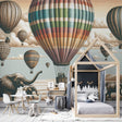 Hot air balloon safari wallpaper creating a magical atmosphere in a bright nursery with gentle elephant silhouettes below