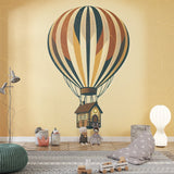 Hot air balloon wallpaper creating a whimsical atmosphere in a bright nursery with natural light and wooden furniture