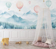 Hot air balloon wallpaper in a bright nursery, pink and mint balloons floating above misty mountains
