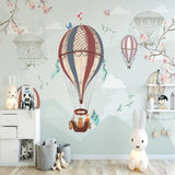 Nursery wall mural with floating balloons complementing a modern baby room setup