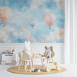 Hot air balloon nursery wallpaper creating a dreamy atmosphere in a modern white nursery with wooden furniture
