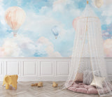 Watercolor balloon wallpaper brightening a child's bedroom with matching pastel decor