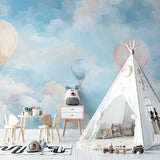 Hot air balloon wall mural in a playroom featuring floating pastel balloons and gentle clouds