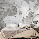 Industrial concrete effect wallpaper in a modern minimalist living room showing textured gray tones and natural shadows