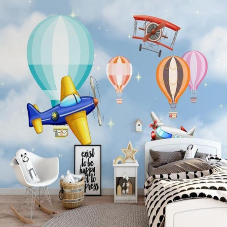 Aviation themed wallpaper in bright nursery with white furniture showing planes and balloons floating above crib